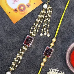 Karatcart Gold-Plated Red Carved Stone Kundan Rakhi, Roli & Chawal for Bhai & Bhabi - Set of 2 image 1