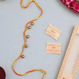 Fabindia Gold-Plated Red Brass Ghungroo Dokra Rakhi with Roli Chawal-image-1